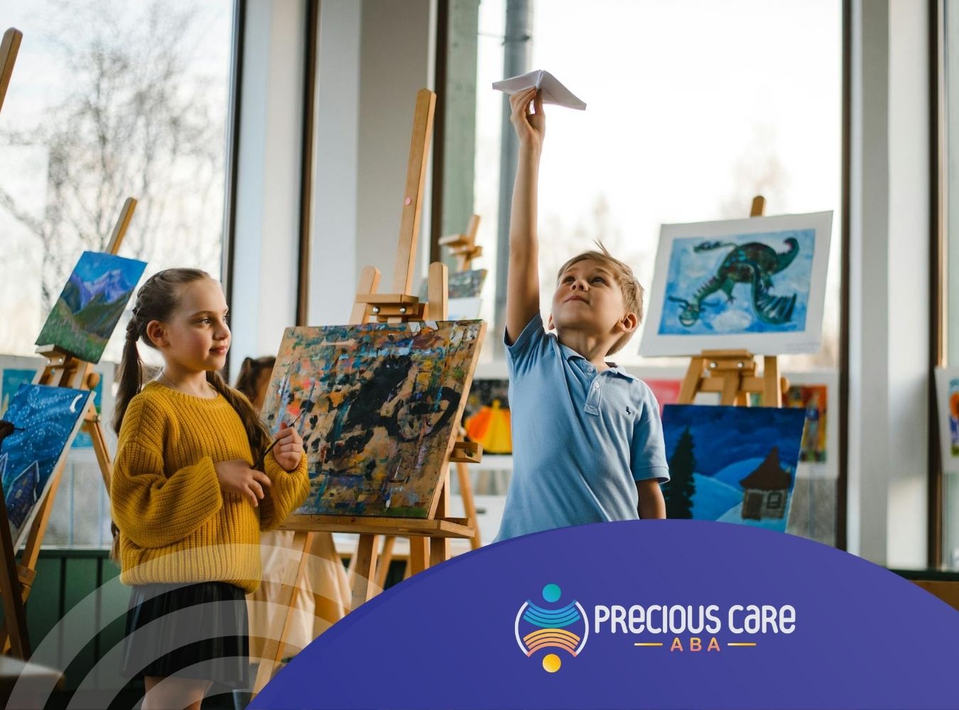 Children with ADHD in art room, with the boy holding paper airplane and paintings displayed in CO.