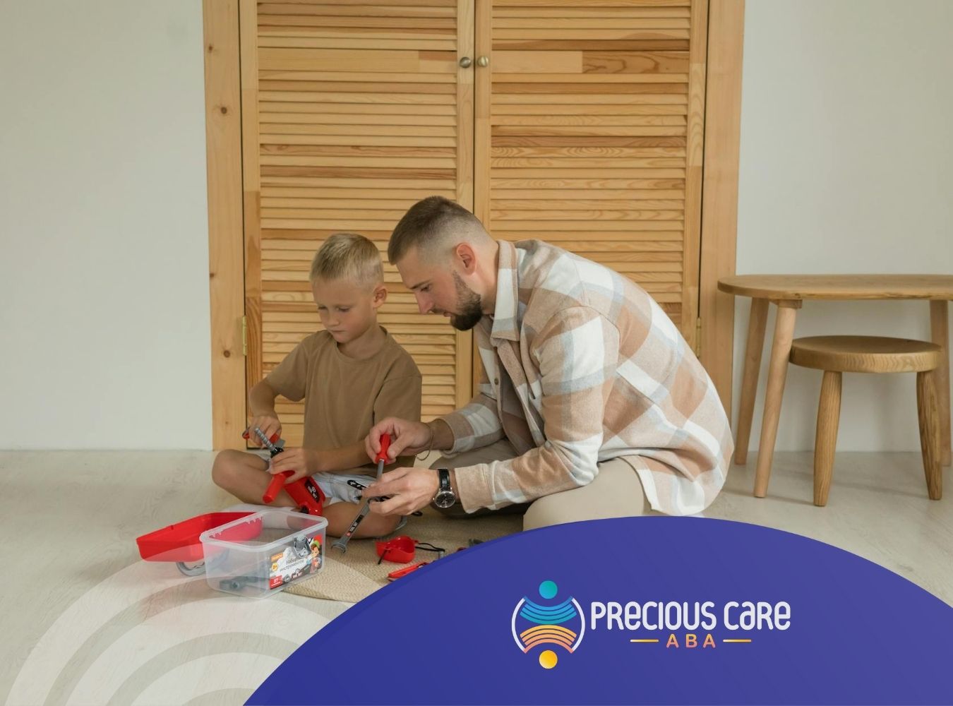 An ABA therapist and autistic child assembling a toy construction set on the floor in Maryland.