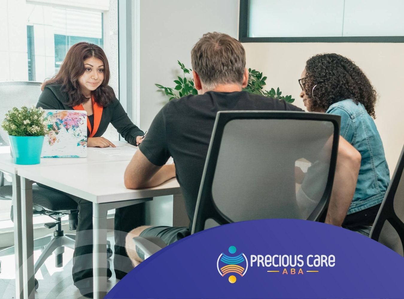 An agent explaining insurance documents for ABA therapy to a couple during an office meeting in CO.