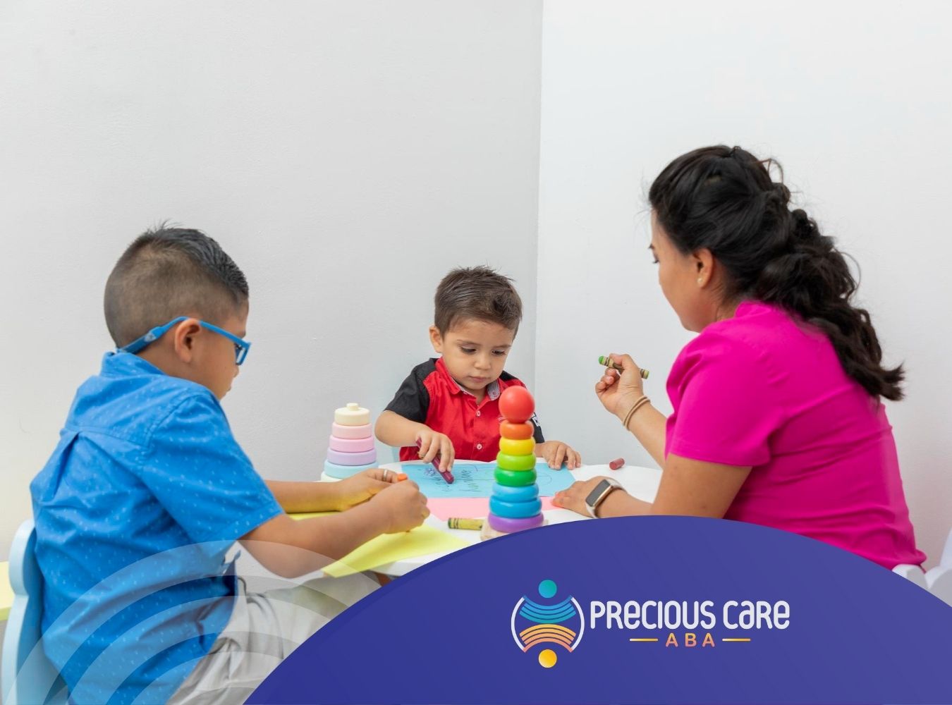 BCBA helping two autistic boys during ABA session.