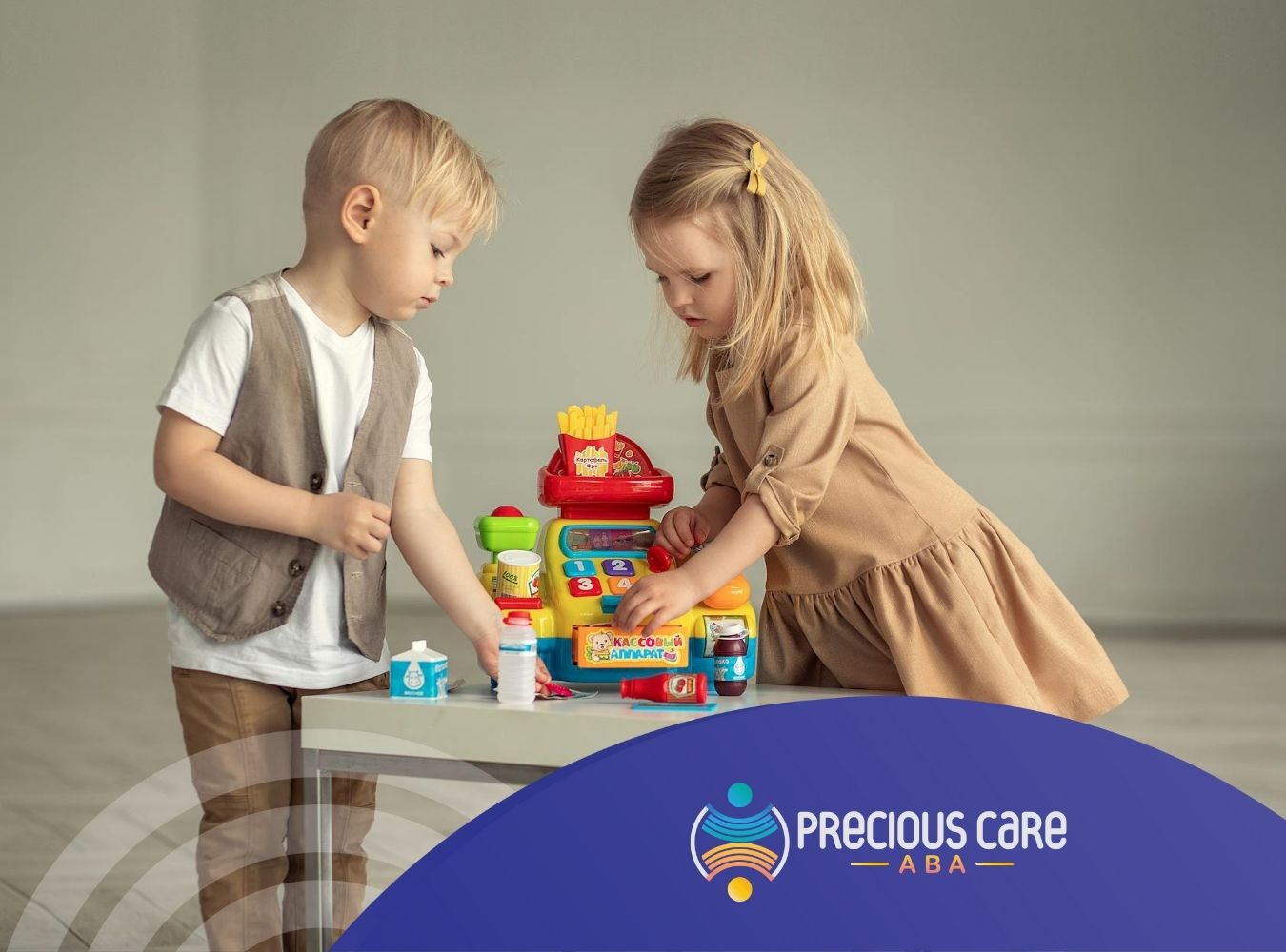 Two autistic toddlers playing with a toy cash register on a small white table at home in Maryland.