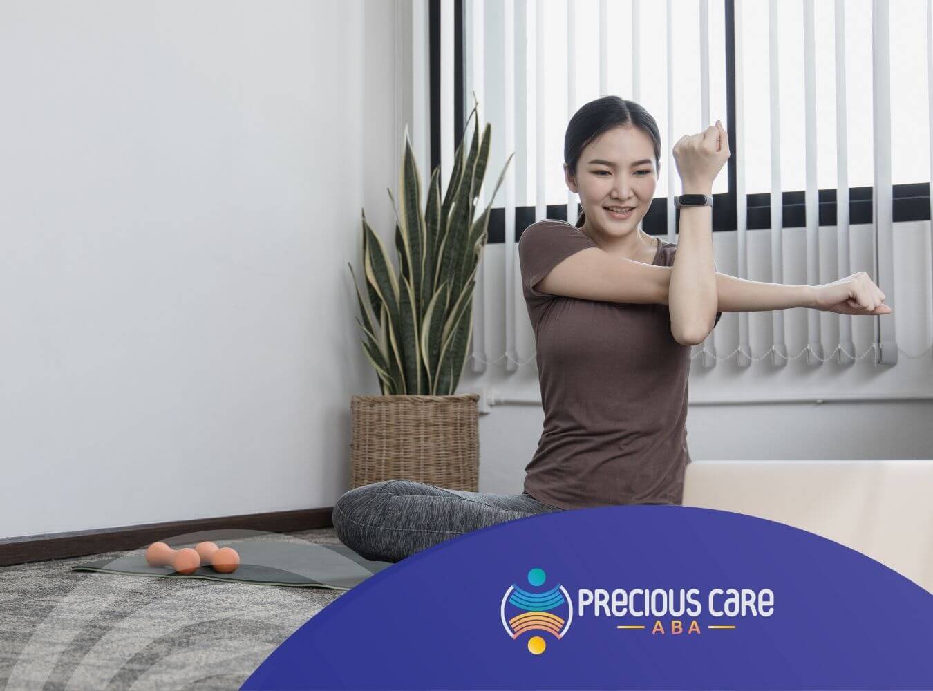 A woman with autism is stretching and smiling while following an online workout class on her laptop.