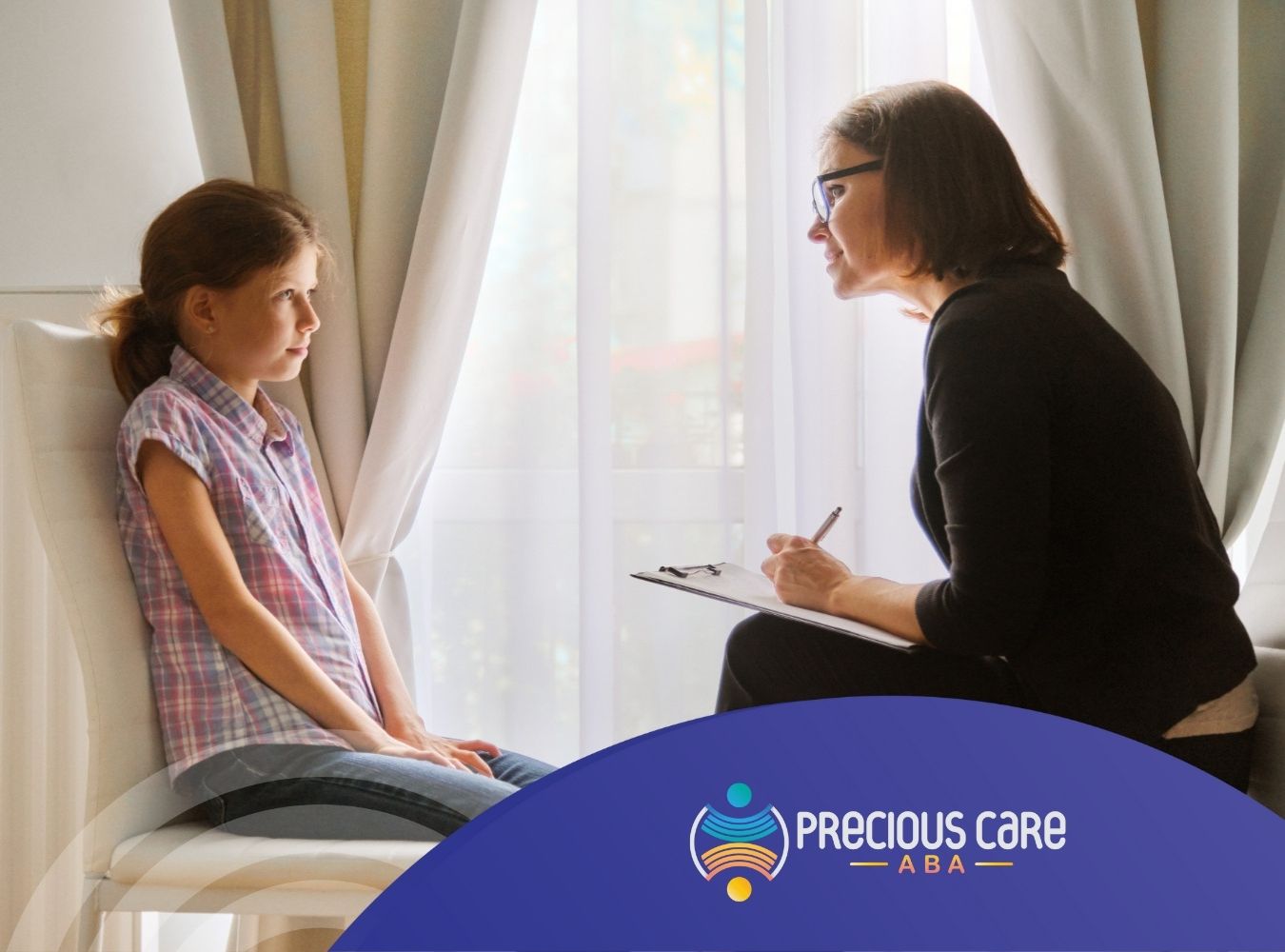 Young girl talking with a female BCBA in a bright room.