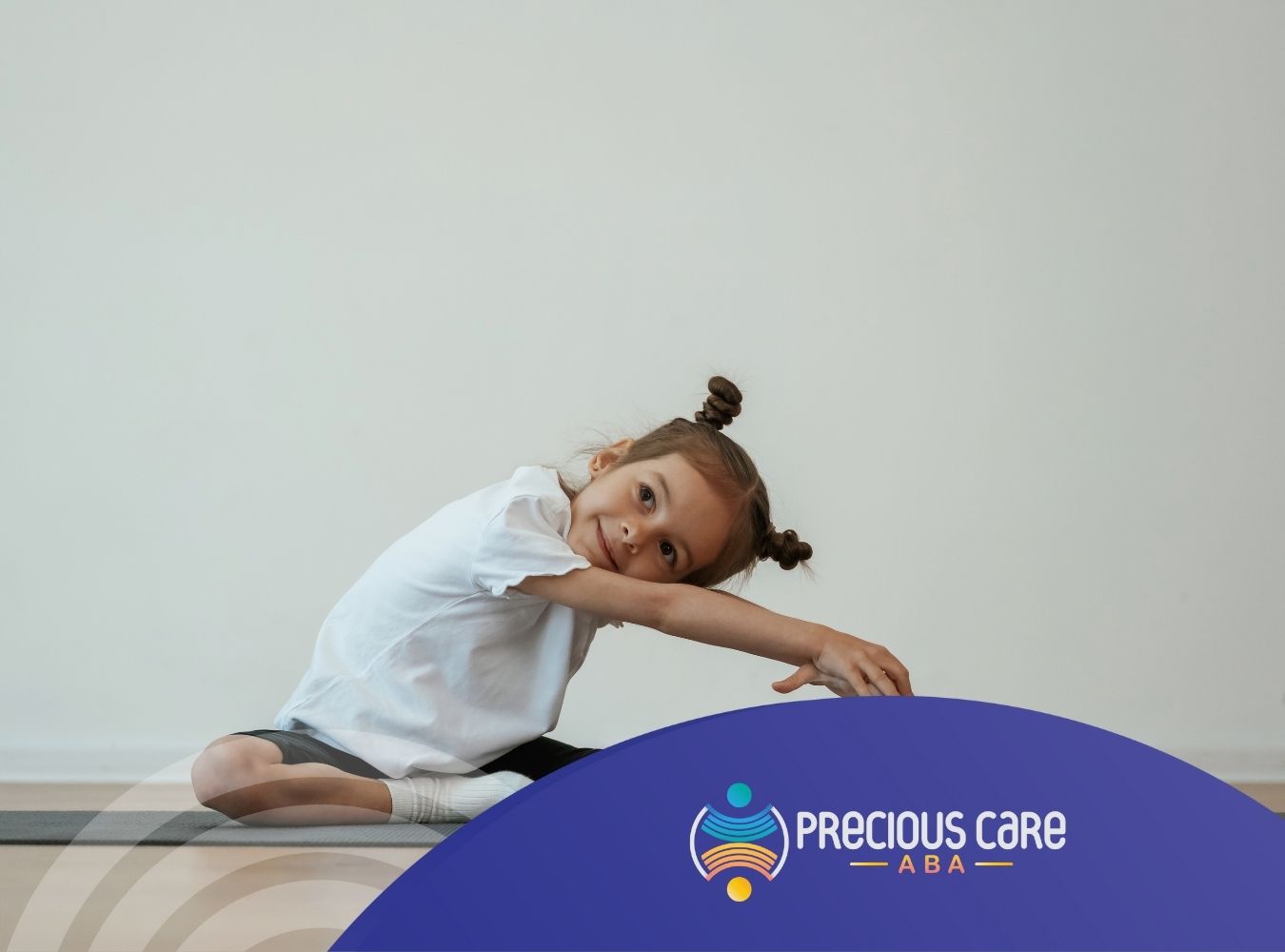 Autistic girl stretching on a yoga mat with a smile.