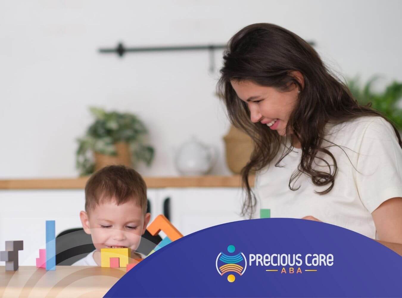 ABA clinician and autistic boy playing with colorful geometric blocks at a table during ABA therapy