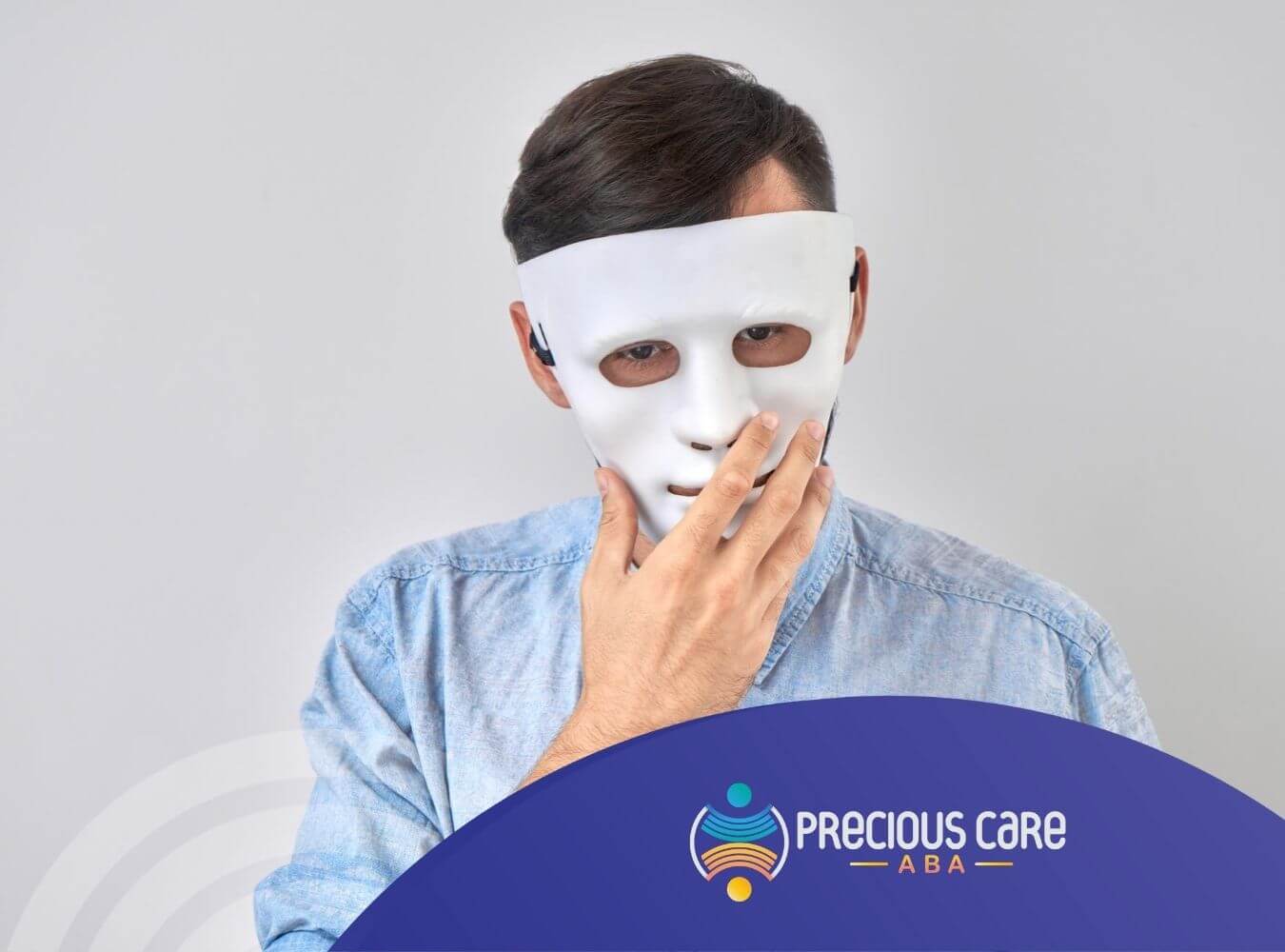 Autistic man wearing white mask touching his face.
