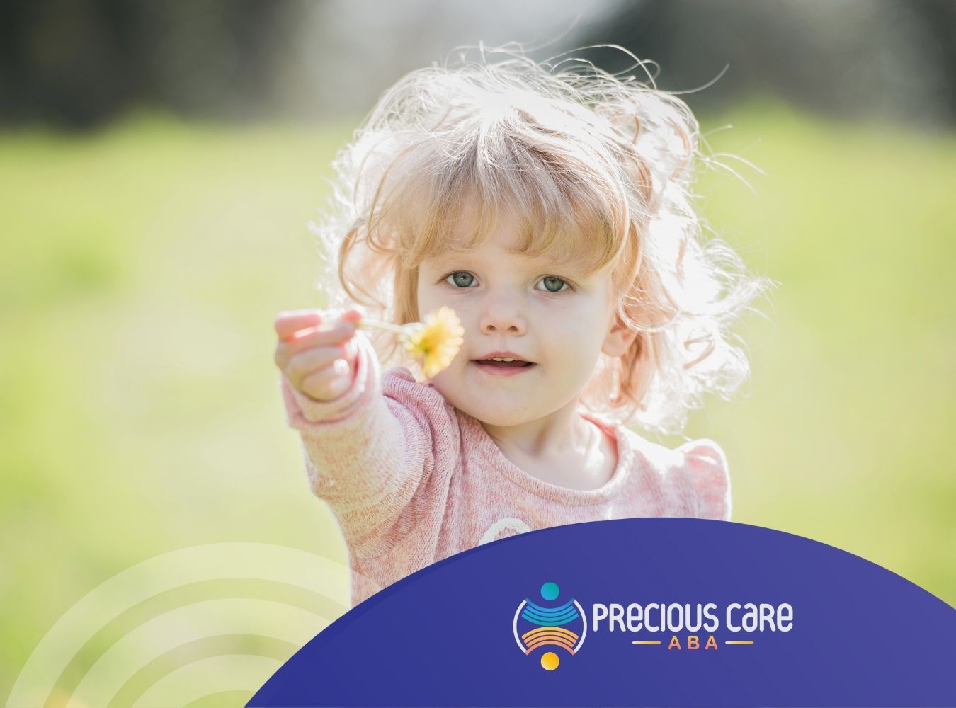 A young child with curly hair smiles at the camera, holding a yellow flower in a sunny field. The atmosphere is warm and joyful.