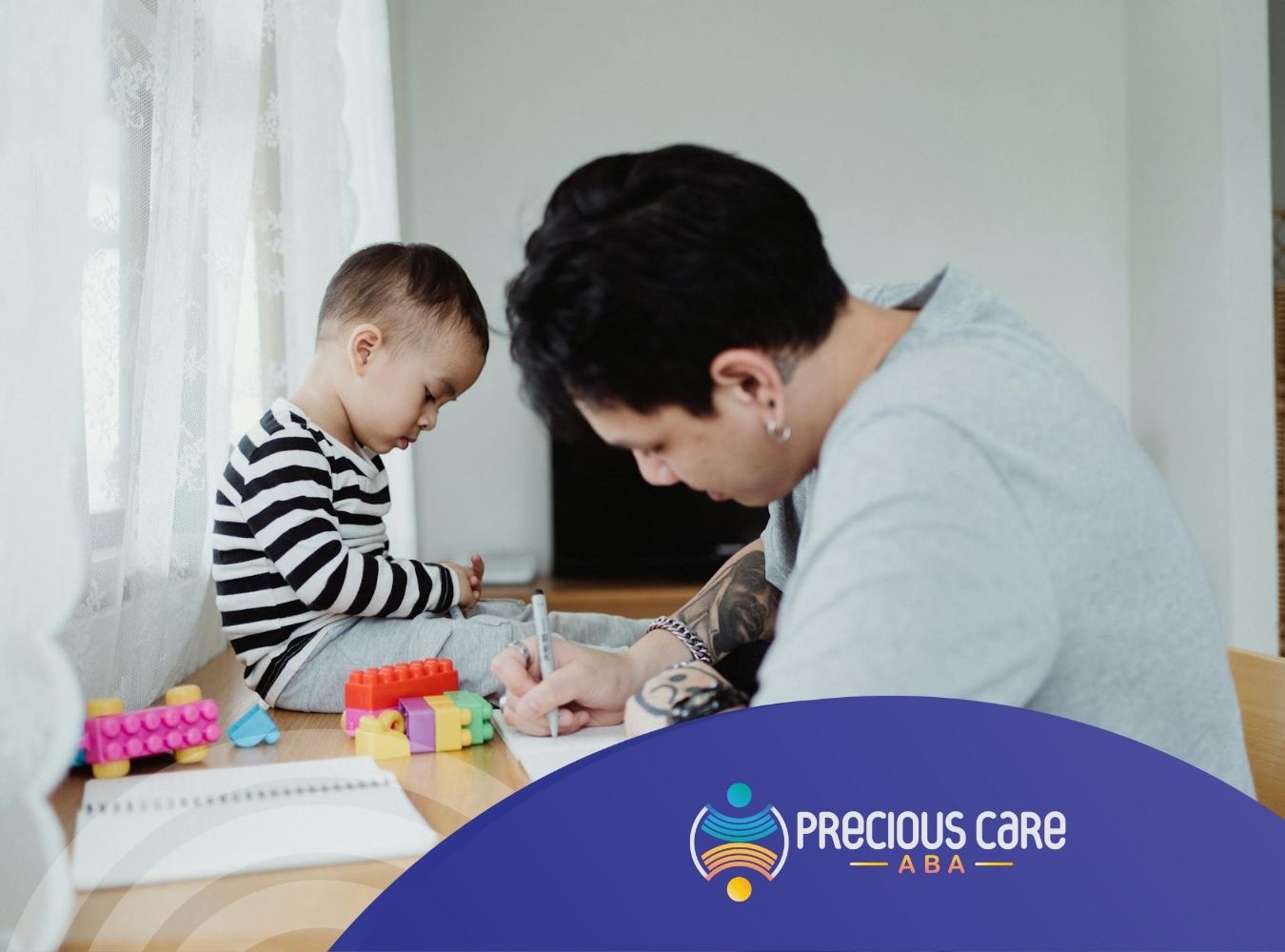 An ABA therapist and autistic child drawing together at a table with building blocks during ABA therapy in MD.
