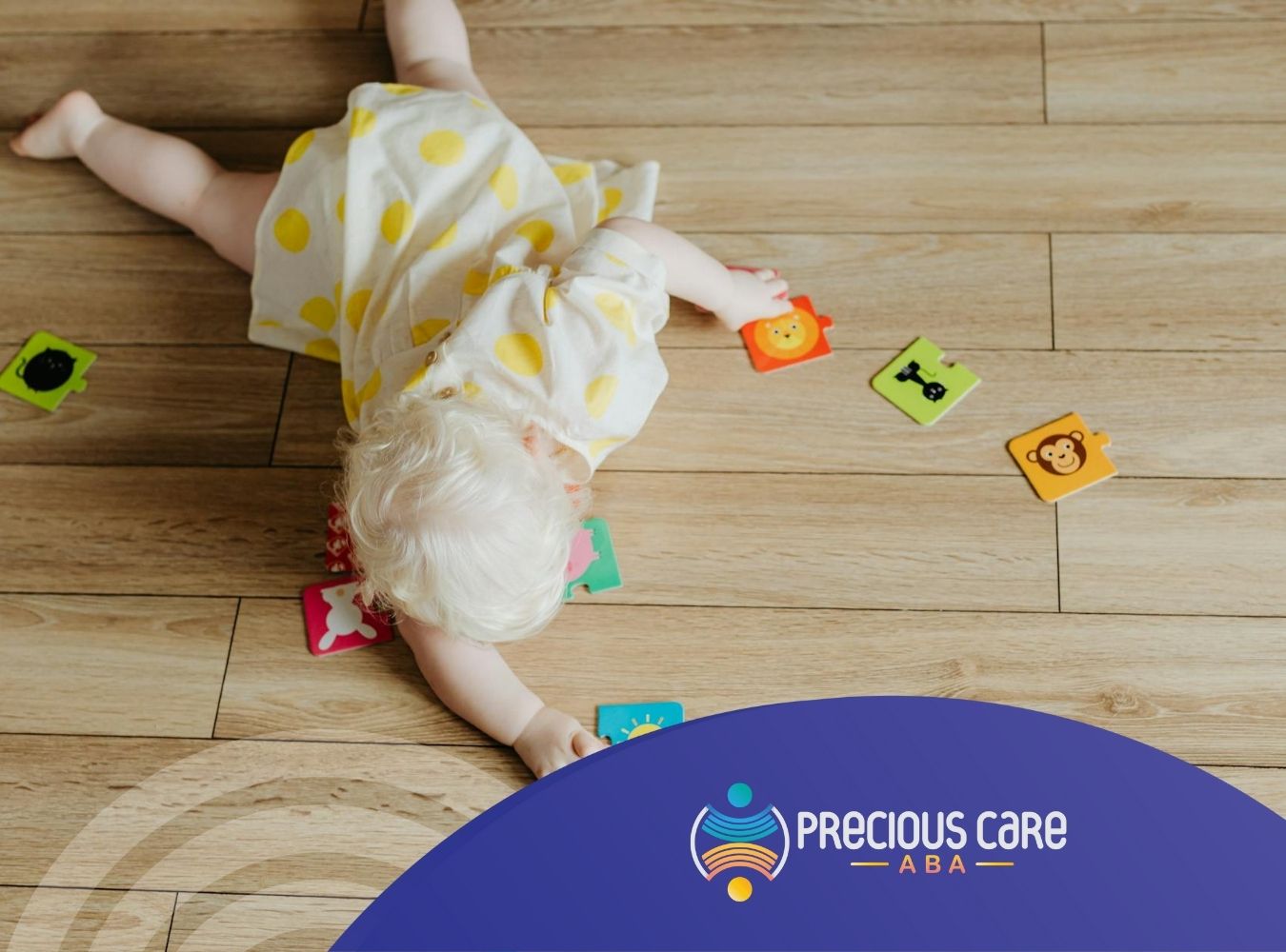 An autistic toddler reaching for colorful puzzle pieces on wooden floor during ABA therapy in MD.