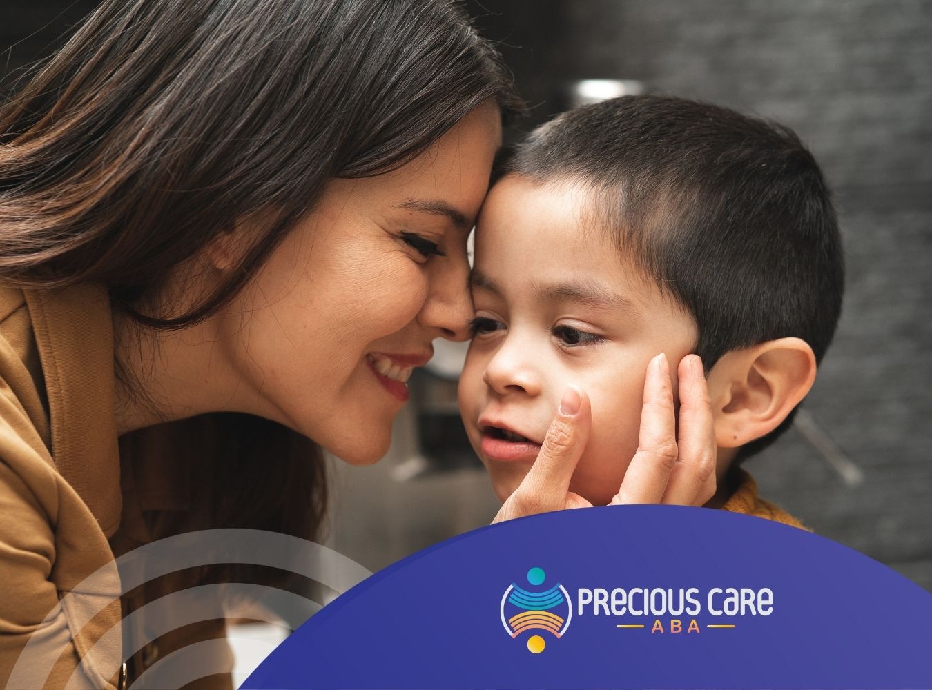 A woman and child smiling warmly, touching foreheads affectionately.