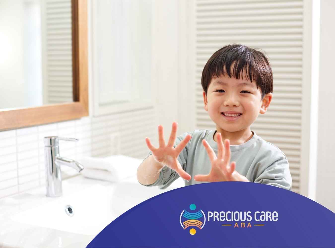 A smiling child stands in a bright bathroom, holding up soapy hands playfully. The scene conveys a sense of happiness and cleanliness.