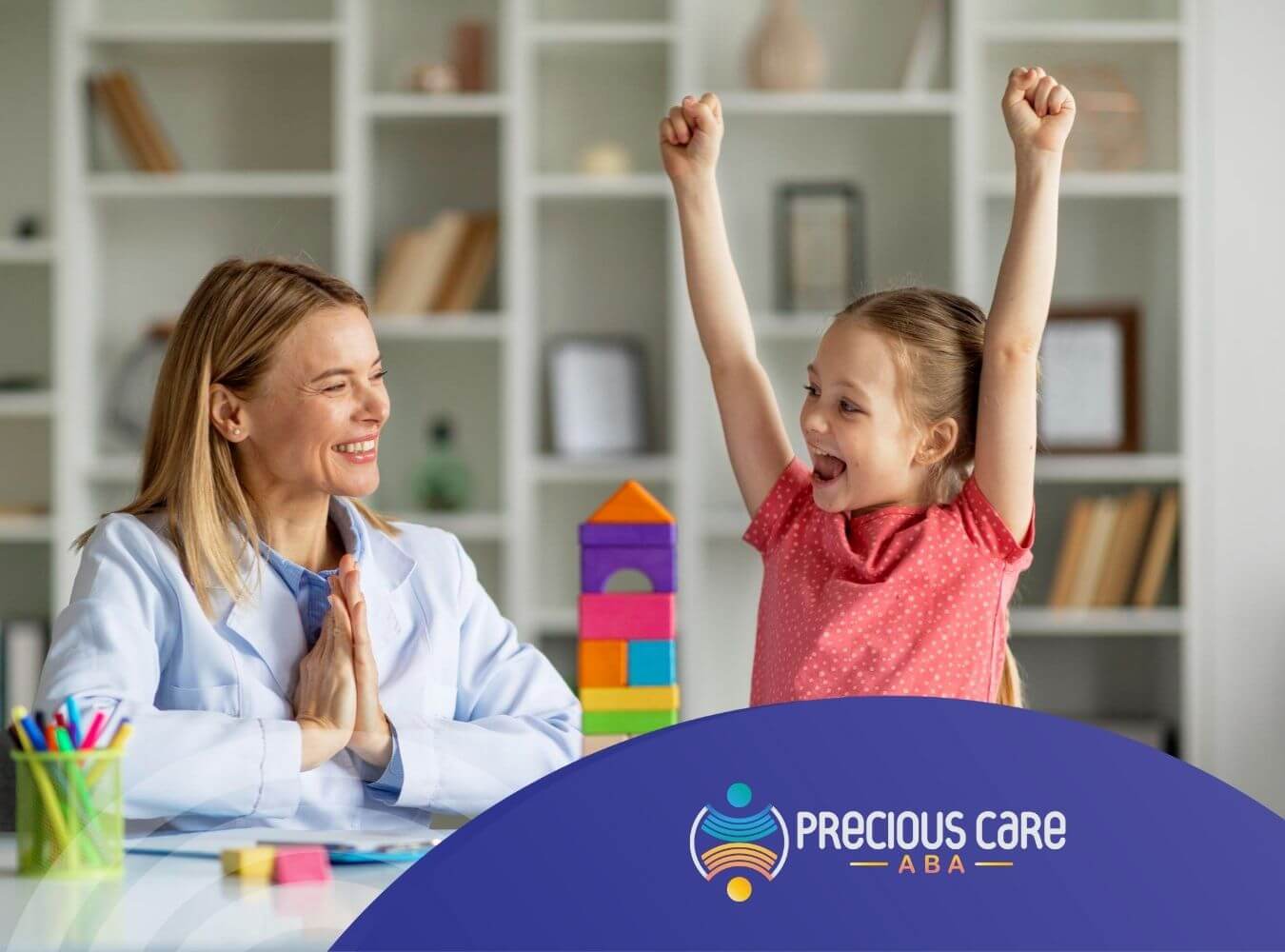 Girl celebrating with BCBA after building colorful block tower in ABA therapy.