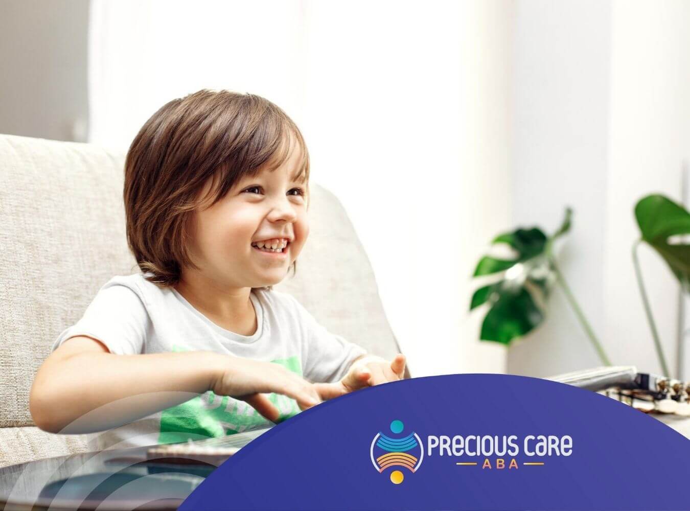 Smiling child with autism playing guitar while sitting on a couch.